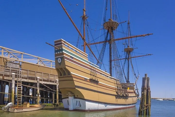 Mayflower II docked at a pier on a sunny day.