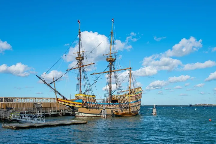 Mayflower II docked at a pier on a sunny day.